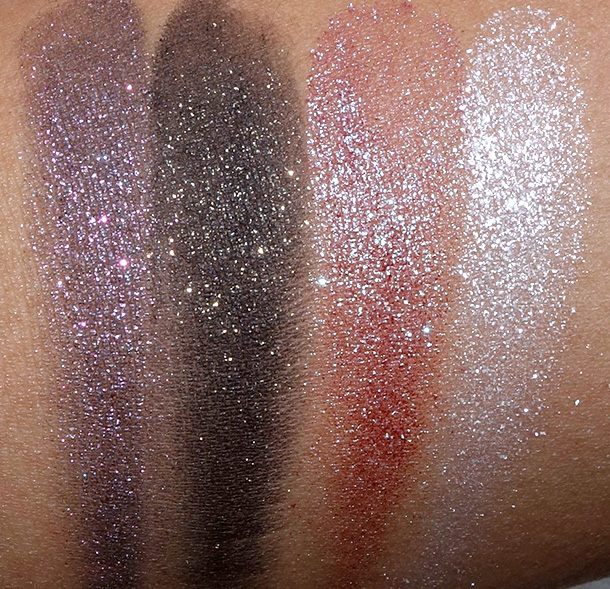 Urban Decay Moondust Eyeshadow swatches from the left: Ether (a light purple with pinkish blue sparkle), Scorpio (a matte black with gold glitter), Solstice (a metallic pinkish red with green shift and shimmer) and Cosmic (a metallic white with iridescent shift)
